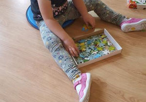Dziewczynka układa puzzle.